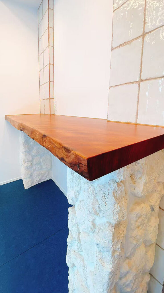 白い擬石CAN'STONE Coral COR-1のカウンター脚と、光沢のあるLIVORNO BLANCOタイルの寄り